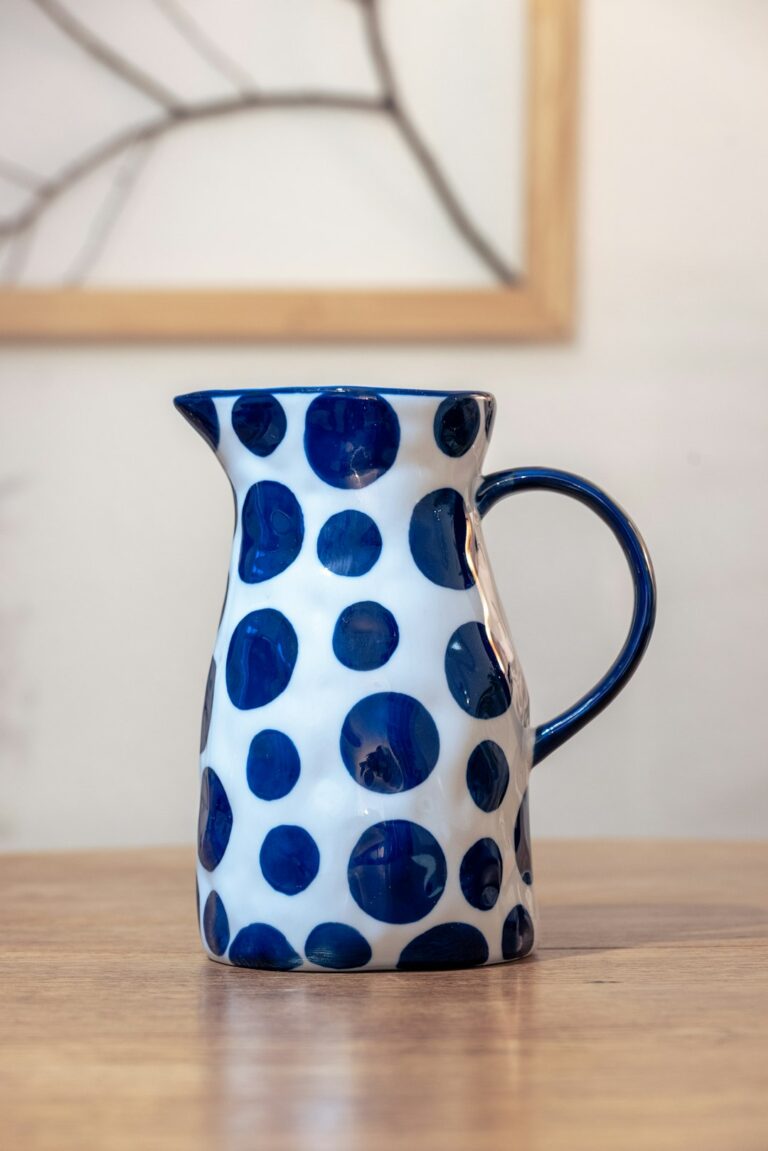 a blue and white vase sitting on top of a wooden table