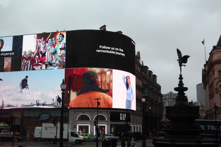 Large digital billboard displaying advertisements above a street corner in London